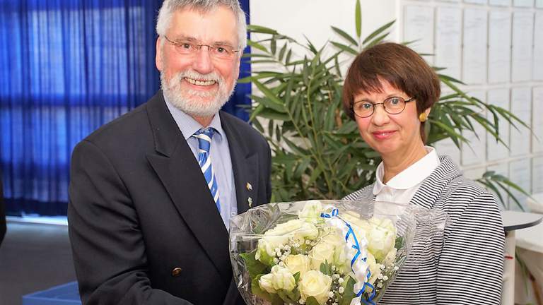 Auch Suse Stelzer ist seit 25 Jahren im Ruderclub Hansa aktiv.  Ulrich Hahn überreicht Suse Stelzer einen Blumenstrauß.